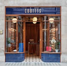 the front entrance to cubitts is decorated with blue tiles and gold trimming