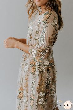 a woman wearing a dress with flowers on it and a hat in her hair is posing for the camera