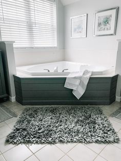 a bath tub sitting next to a window in a bathroom