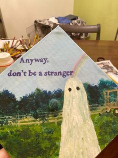 someone is holding up a graduation cap with an image of a ghost in the background