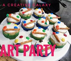 cupcakes with white frosting and colorful toppings on a cake platter