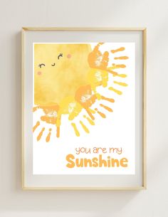 an orange and yellow print with the words you are my sunshine on it in front of a white wall