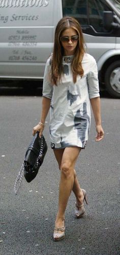 a woman walking down the street carrying a purse