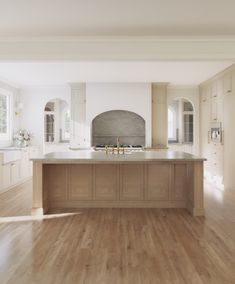 a large kitchen with an island in the middle and wood flooring on the other side