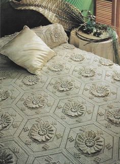 a crocheted bedspread and pillows on a bed