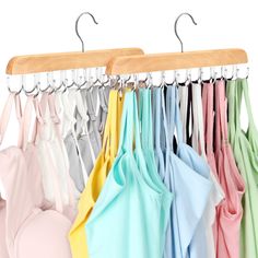 several shirts hanging on a wooden hanger with clothes in different colors and shapes,