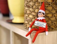 an elf sitting on top of a shelf next to a basket