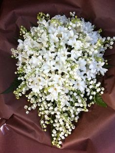 a bouquet of white flowers sitting on top of a brown cloth