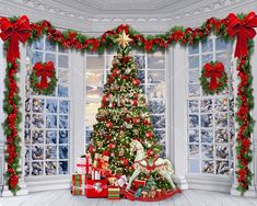 a christmas tree in front of a window with presents under it and stockings on the floor