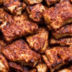 close up view of tofu cubes with marinara sauce on top, ready to be eaten