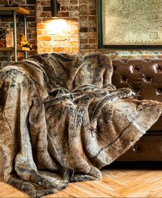 a living room with a brown couch covered in blankets