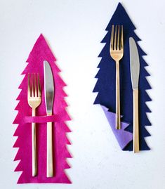 two forks and spoons sitting next to each other on top of pink napkins