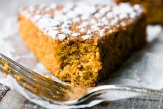 a piece of cake with powdered sugar on top and a fork next to it