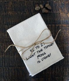 a piece of paper with writing on it sitting on top of a wooden table next to some nuts