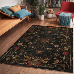 a black area rug with flowers and leaves on it in a living room next to a red chair