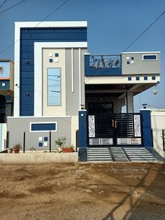 a blue and white house sitting on the side of a road