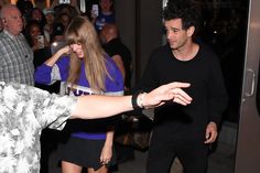 a man and woman dancing in front of a large group of people at night time