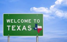 a green welcome to texas highway sign against a blue sky with white puffy clouds