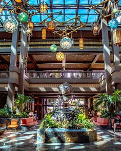 the inside of a hotel lobby with chandeliers hanging from it's ceiling