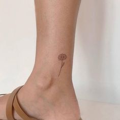 a woman's foot with a small flower tattoo on her left side calfocks