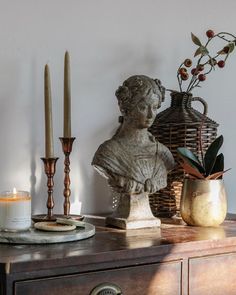 a table topped with a statue and candles