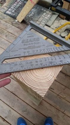 someone is holding a piece of wood that has been cut in half with a pair of scissors