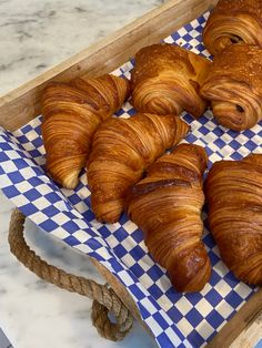 several croissants on a blue and white checkered tray