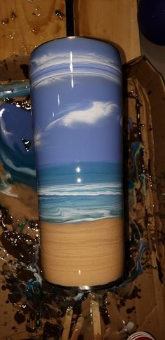 a blue and white vase sitting on top of a wooden table next to other items