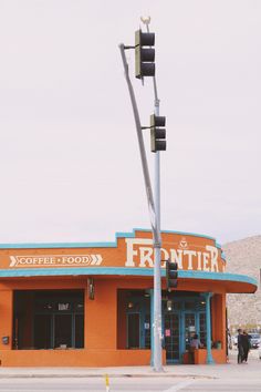 an orange and blue building with a traffic light on the corner in front of it