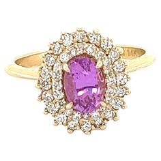 This beautiful ring has a Natural Oval Cut Heated Pink Sapphire that weighs 0.94 Carats. The Pink Sapphire is 7 mm x 5 mm. The ring is embellished with 40 Round Cut Diamonds that weigh 0.40 Carats with a clarity and color of VS/F. The total carat weight of the ring is 1.34 Carats. The ring is beautifully set in 14 Karat Yellow Gold with an approximate weight of 4.0 grams. It is a size 6 3/4 and can be re-sized if needed, free of charge.