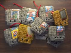 crocheted nintendo gameboy pouches on a wooden table with red string around them