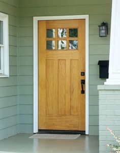 the front door of a house with glass panes on it's side window