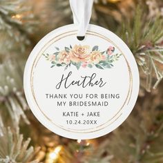 a personalized wedding ornament hanging from a christmas tree with flowers on it