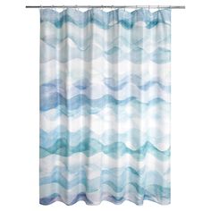 a blue and white shower curtain with wavy watercolor waves on the bottom, in front of a white background