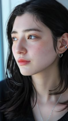 a close up of a person wearing a necklace and earring with earrings on her head