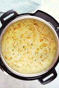 a pot filled with soup sitting on top of a stove next to a blue towel