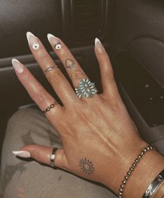 a woman's hand with several rings on it