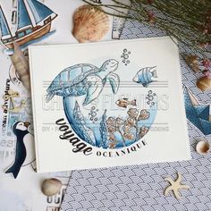 an ocean themed card with sea animals and marine life on it, surrounded by seashells