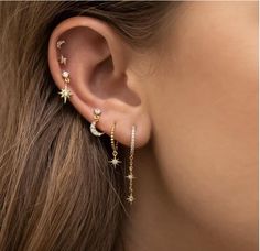 a woman's ear with stars and moon earrings