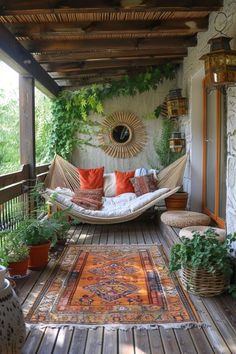 a hammock hanging from the ceiling on a porch with plants and potted plants