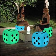 two women are sitting on the deck with glowing dices in front of their faces