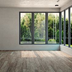 an empty room with large windows and wood flooring on the outside, looking out onto a wooded area