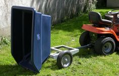 a red lawn mower sitting next to a blue trash can