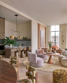 a living room filled with lots of furniture next to a kitchen and dining room table