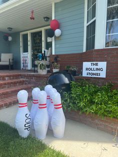 three bowling stones sitting in front of a house