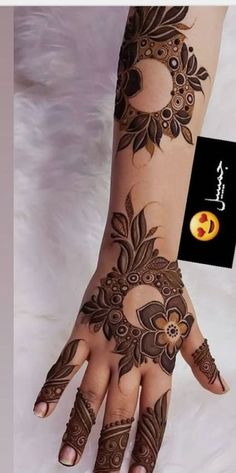 a woman's hand with henna tattoos on it