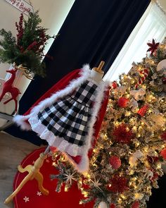 a christmas tree with a santa hat on top and other holiday decorations around the tree