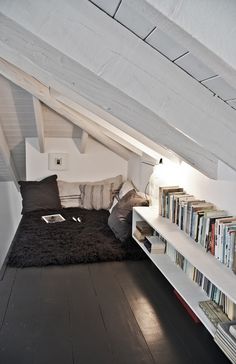 an attic bedroom with bookshelves and a bed