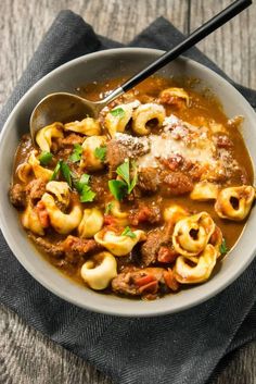 a bowl filled with pasta and meat sauce