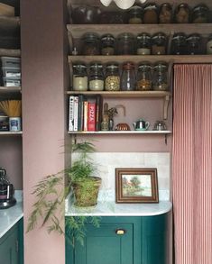 a kitchen with green cupboards and shelves filled with items